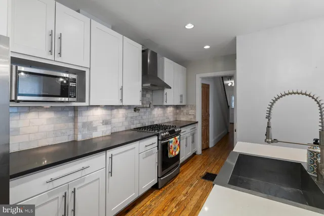 a kitchen with stainless steel appliances granite countertop a stove a sink and a microwave