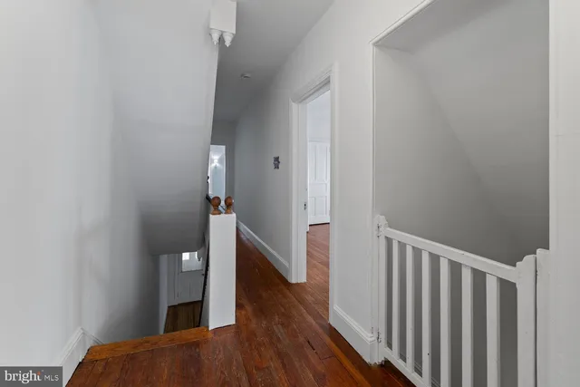 a view of a hallway with wooden floor and staircase