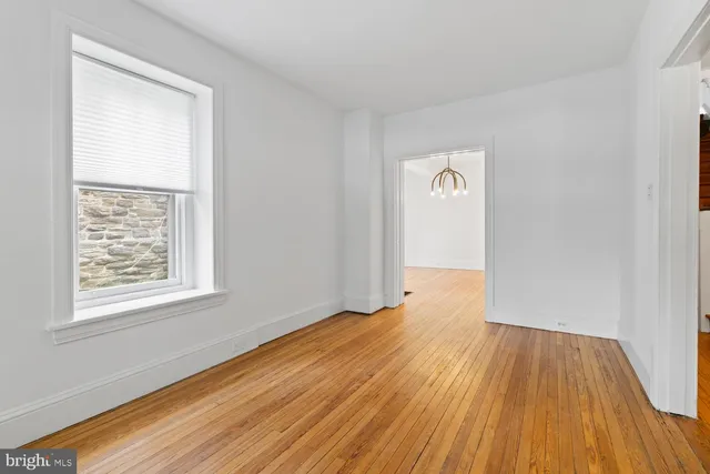 an empty room with wooden floor and a window