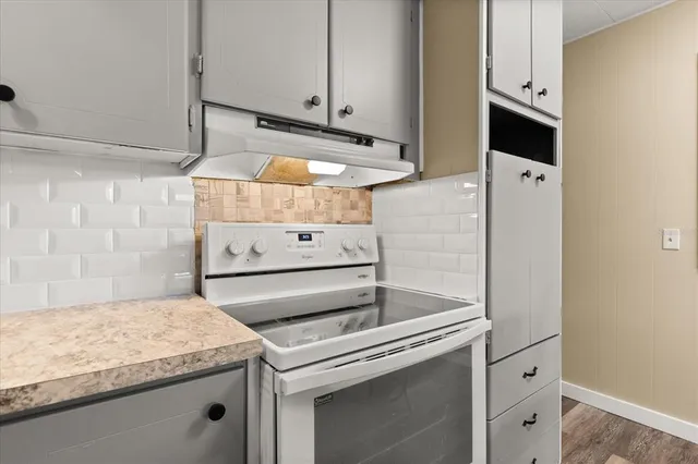 a kitchen with granite countertop white cabinets and white appliances