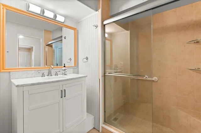 a bathroom with a shower sink and mirror