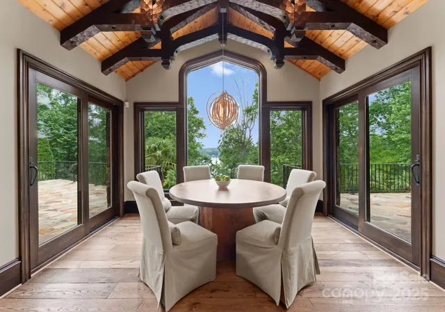 a view of a dining room with furniture large windows and outside view