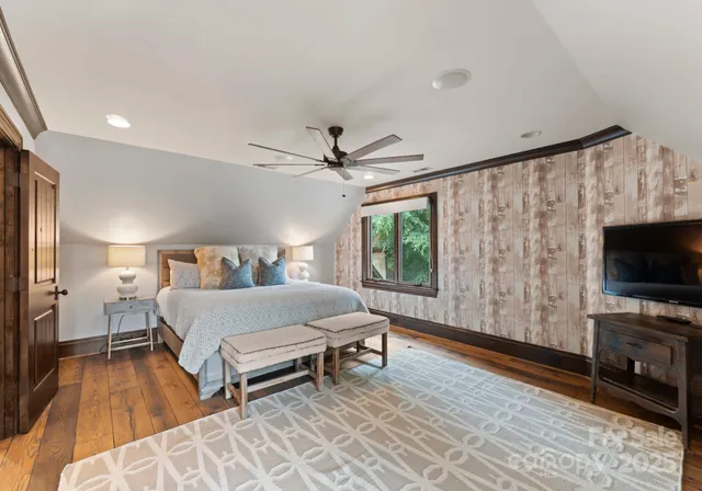 a spacious bedroom with a bed and a flat screen tv