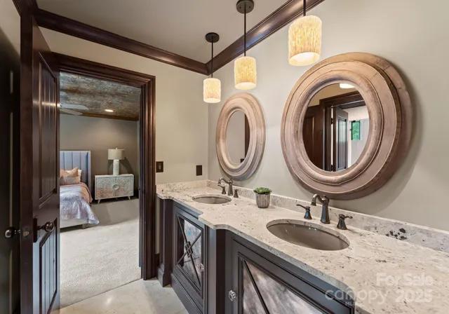 a en suite bathroom with a granite countertop double vanity sink and a mirror
