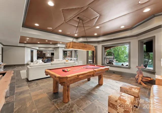a room with pool table and windows