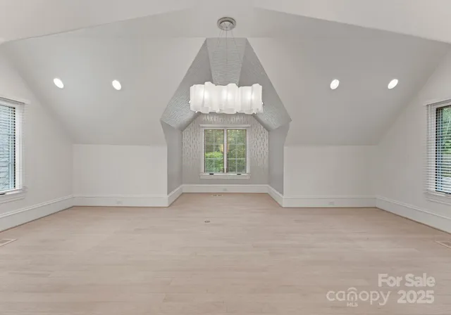 an empty room with a windows and chandelier