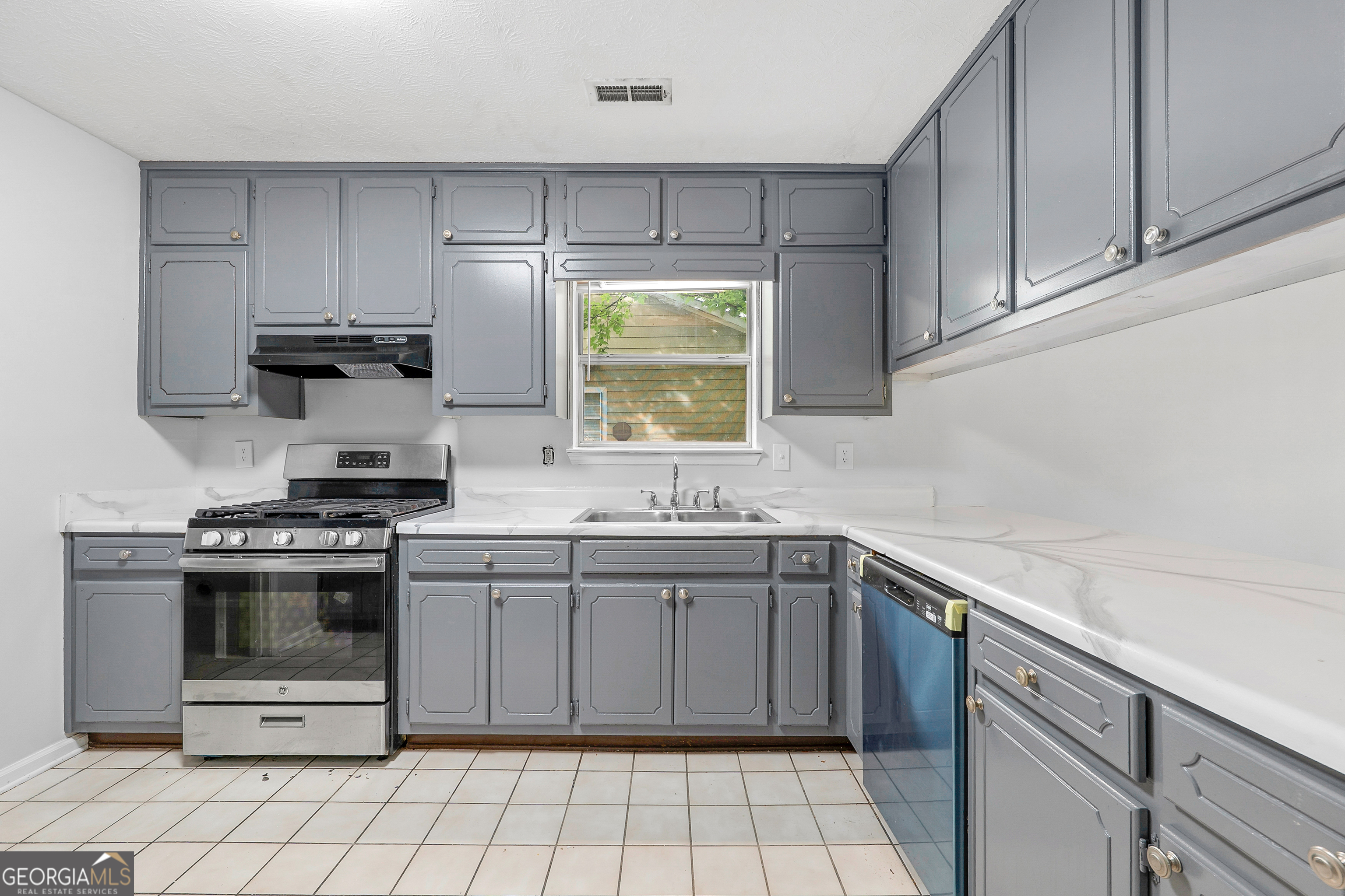 1328 Foxvale Drive Hampton, GA 30228 - Photo 4 of 27 a kitchen with a stove sink and cabinets