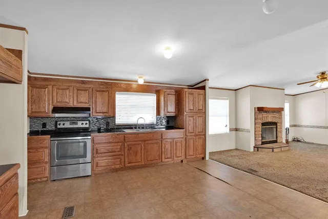 a kitchen with stainless steel appliances granite countertop a stove a sink and a refrigerator