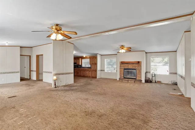 a view of a livingroom with a fireplace and a window