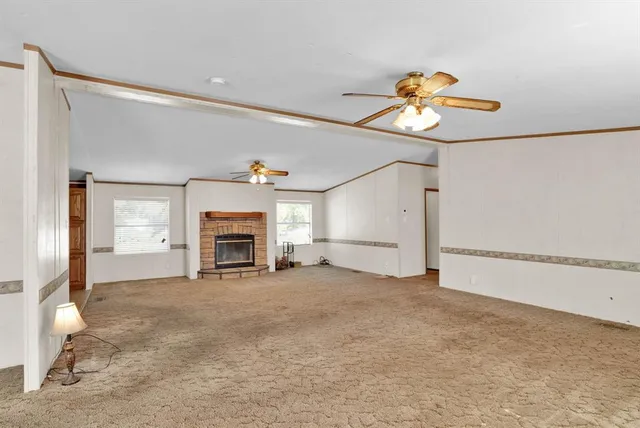 a view of a livingroom with a fireplace and chandelier fan