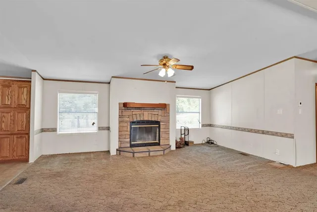 a view of empty room with a fireplace and window