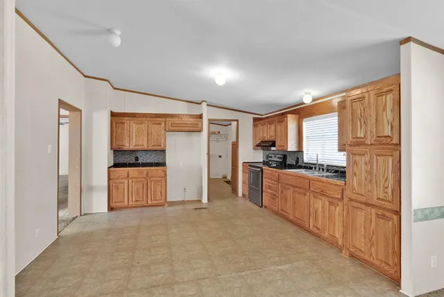 a large kitchen with stainless steel appliances granite countertop a refrigerator and a stove top oven