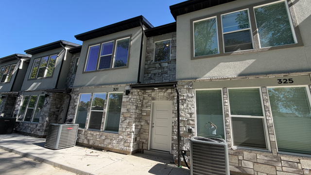 321 East 750 North, Unit 13 Ogden, UT 84404 - Photo 1 of 1 Modern townhome exterior featuring a stone and stucco facade, multiple large windows, and a prominent front door