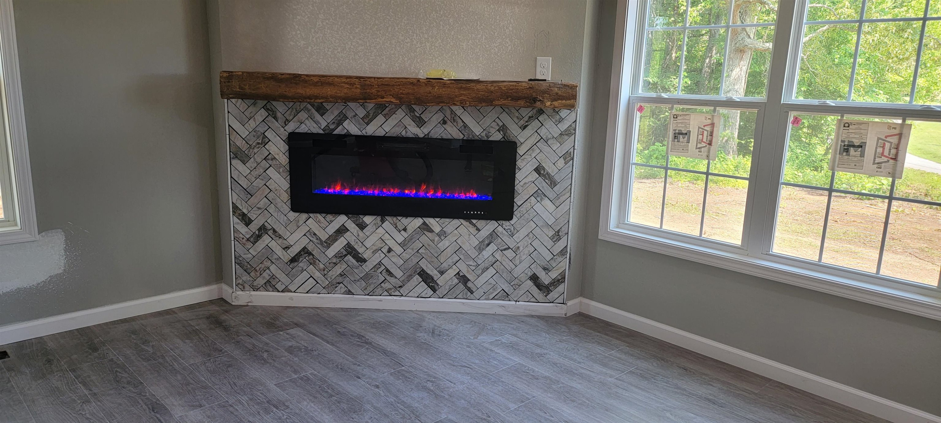 920 Tyler Road Lexington, TN 38351 - Photo 5 of 17 a room with wooden floor a fireplace and a large window