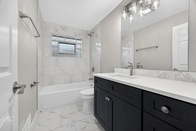 a bathroom with a tub a sink and mirror