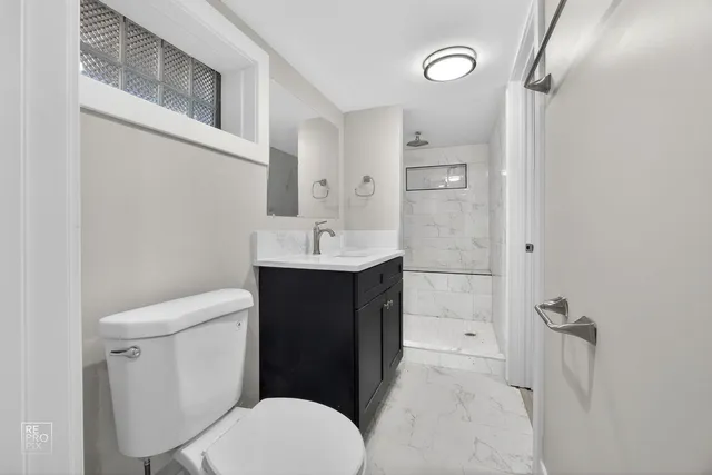 a bathroom with a sink a toilet and shower