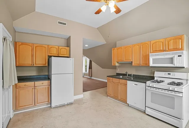 a kitchen with stainless steel appliances granite countertop a stove a refrigerator and a cabinets