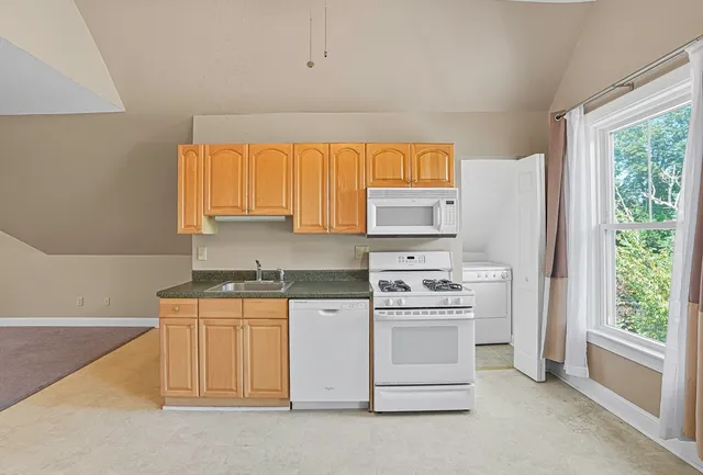 a kitchen with white cabinets and white appliances