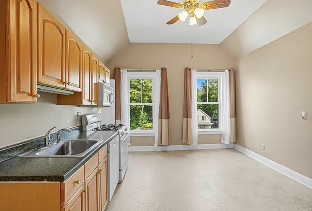 a kitchen with stainless steel appliances granite countertop a sink a stove and a refrigerator with wooden floor