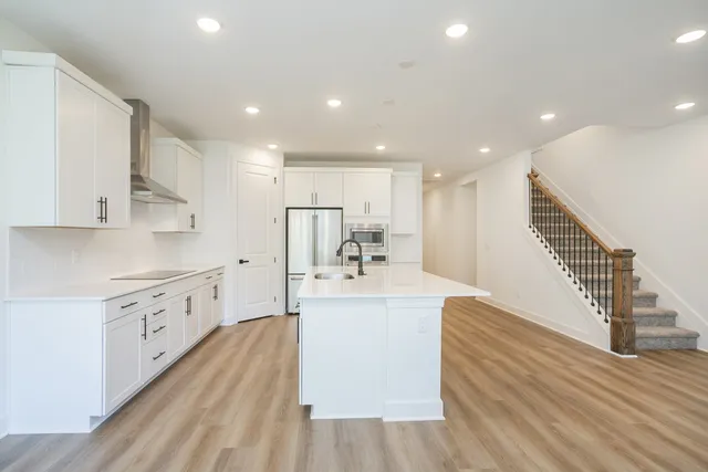 a view of kitchen with wooden floor and electronic appliances