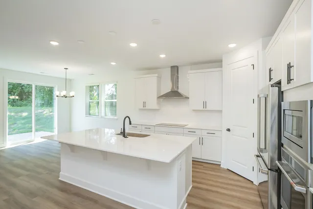 a kitchen with kitchen island a counter top space a sink stainless steel appliances and cabinets