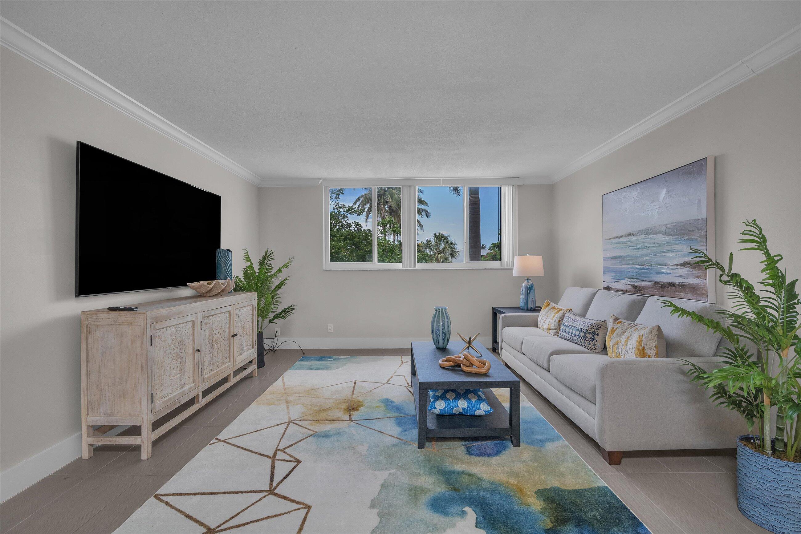 601 North Ocean Boulevard, Unit 203 Boca Raton, FL 33432 - Photo 10 of 20 a living room with furniture and a flat screen tv