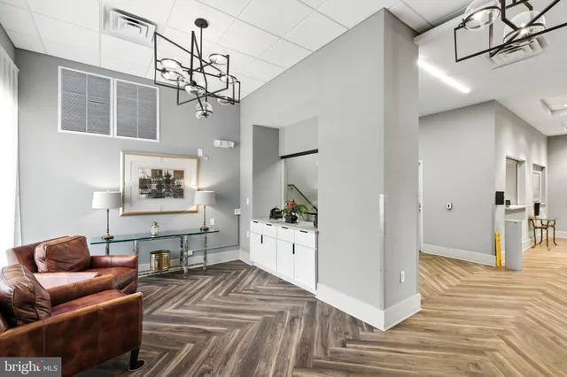 a living room with furniture a chandelier and a wooden floor