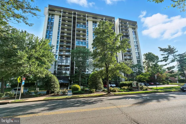 a view of a tall building next to a yard