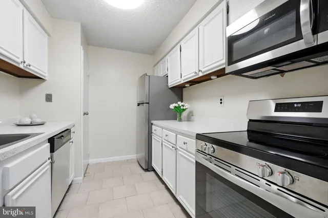 a kitchen with stainless steel appliances white cabinets and stove