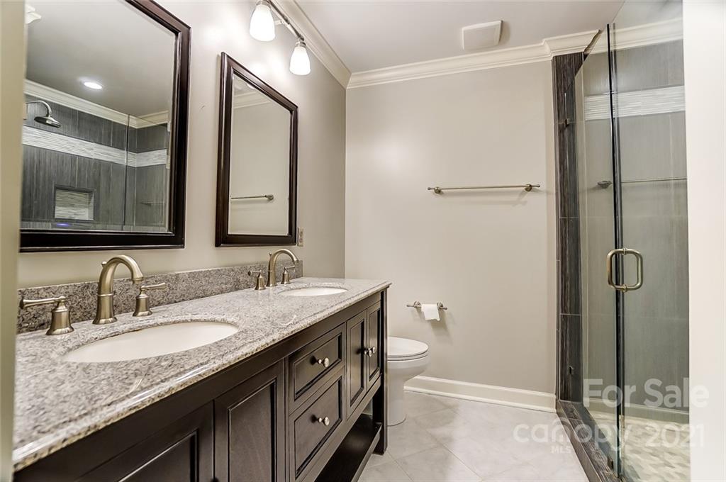 416 Queens Road, Unit 14 Charlotte, NC 28207 - Photo 19 of 27 a bathroom with a granite countertop sink toilet and shower
