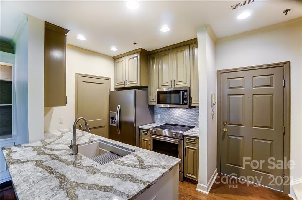 416 Queens Road, Unit 14 Charlotte, NC 28207 - Photo 3 of 27 a kitchen with stainless steel appliances granite countertop a refrigerator a stove and a sink