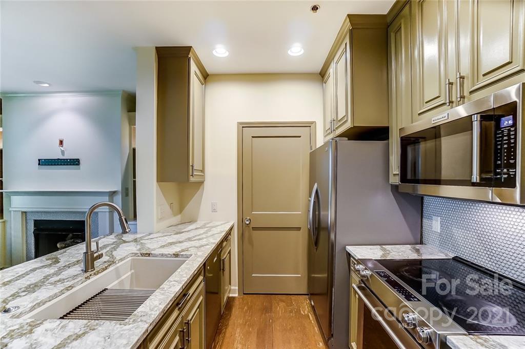 416 Queens Road, Unit 14 Charlotte, NC 28207 - Photo 6 of 27 a kitchen with stainless steel appliances granite countertop a sink stove and refrigerator