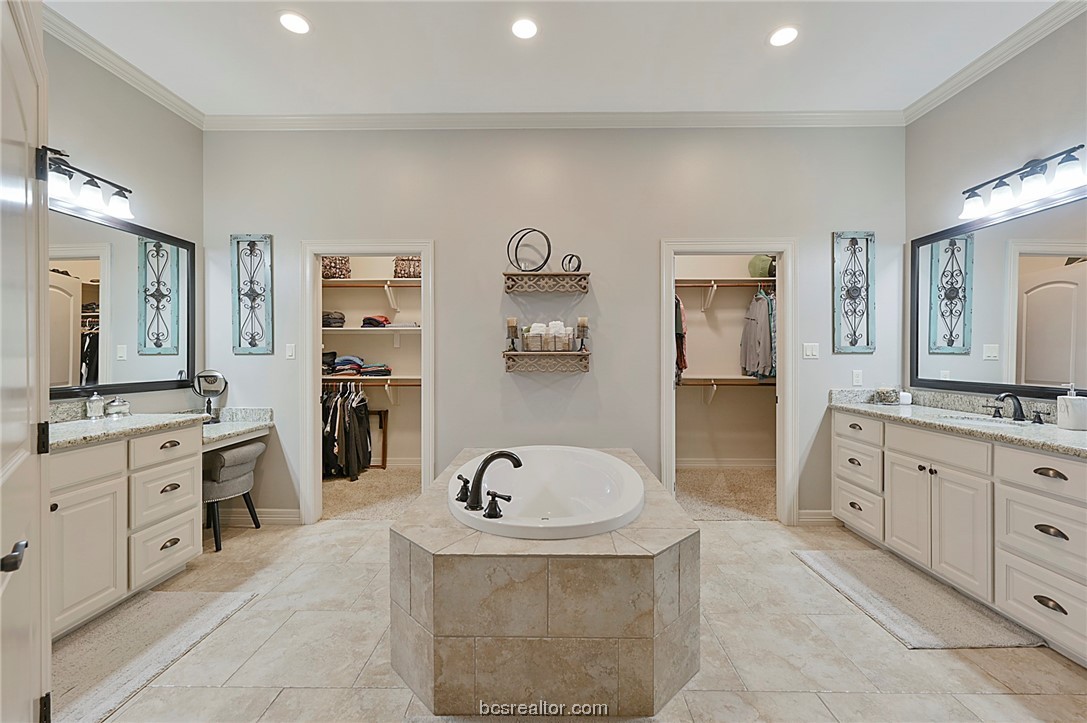a spacious bathroom with a tub sink and mirror