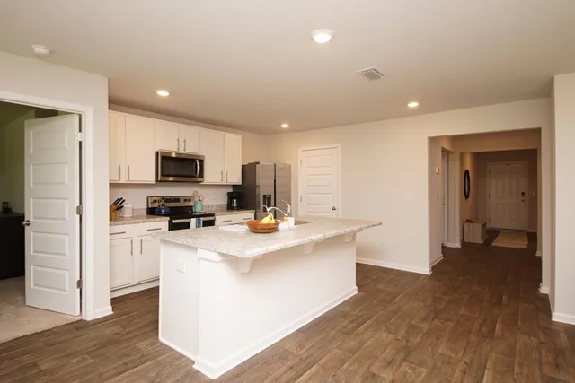 a kitchen with a sink dishwasher a stove and a microwave oven with cabinets