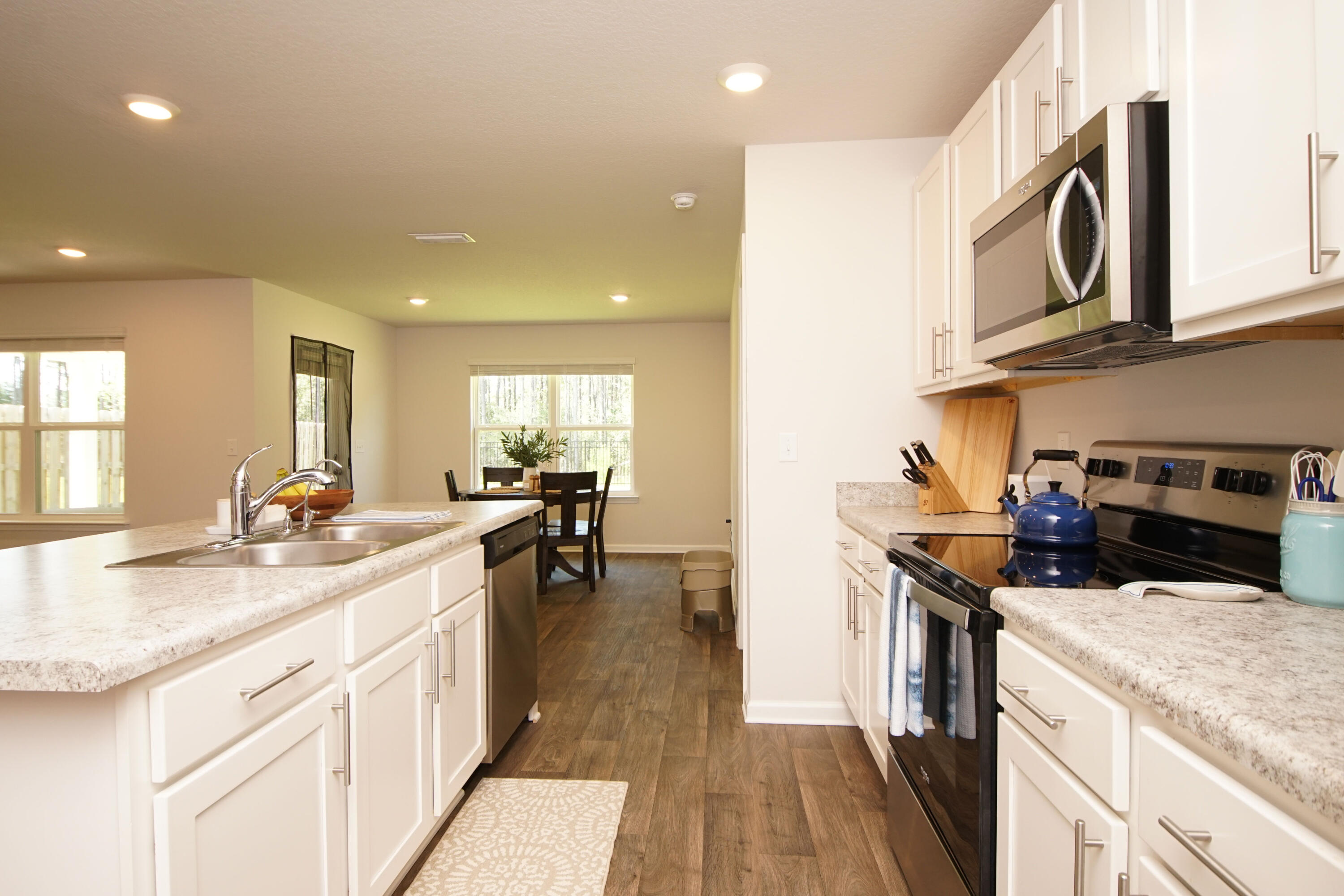 334 This Way Freeport, FL 32439 - Photo 13 of 55 a kitchen with a sink dishwasher a stove and a microwave oven with cabinets