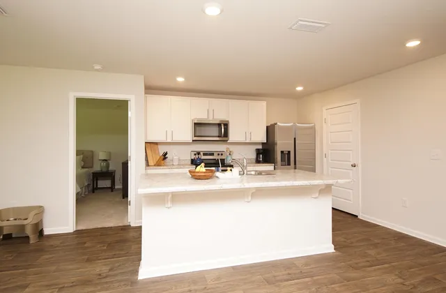 a kitchen with stainless steel appliances granite countertop a sink stove microwave and refrigerator