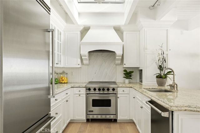 a kitchen with granite countertop white cabinets and white appliances