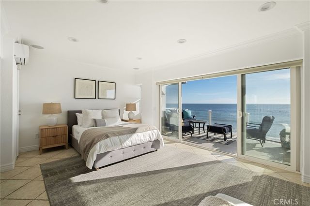 a bedroom with a bed large mirror and furniture