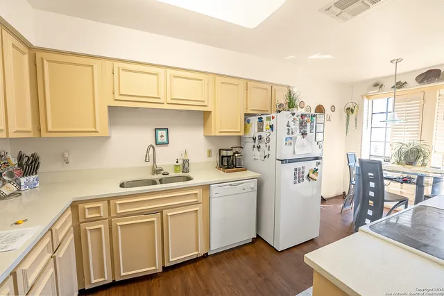 a kitchen with kitchen island white cabinets and white appliances