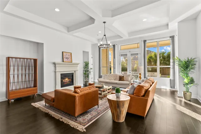 a living room with patio furniture and a chandelier