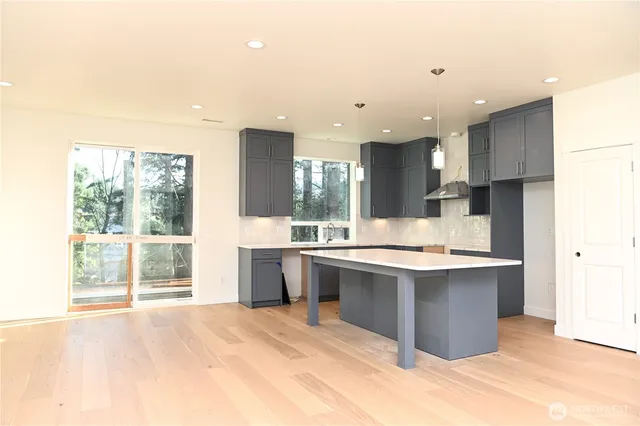 a large kitchen with kitchen island a sink stainless steel appliances and cabinets