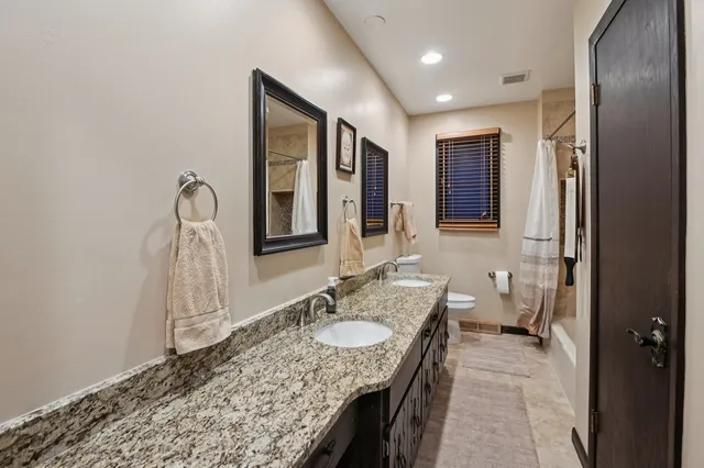 a bathroom with a granite countertop sink a mirror and a bathtub