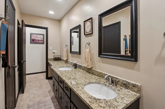 a bathroom with a granite countertop sink and a mirror