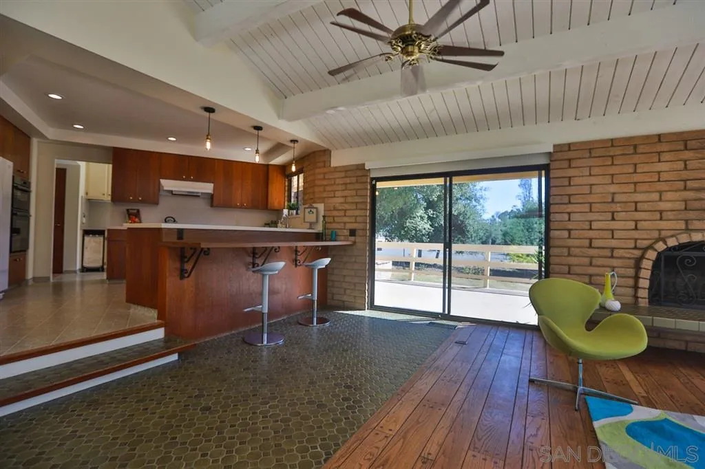 1211 Palomino Road Fallbrook, CA 92028 - Photo 13 of 25 a living room with kitchen island furniture a rug and a large window