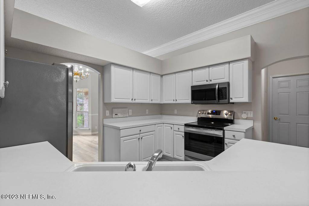691 Nottingham Forest Circle St. Johns, FL 32259 - Photo 14 of 44 a kitchen with stainless steel appliances kitchen island granite countertop a refrigerator stove top oven and sink