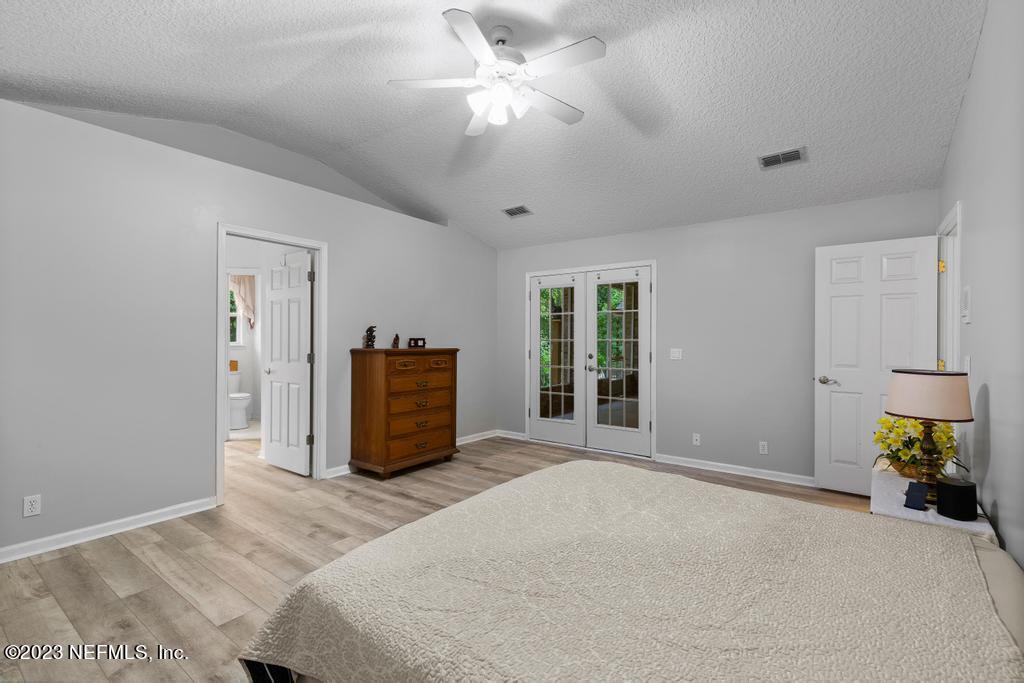 691 Nottingham Forest Circle St. Johns, FL 32259 - Photo 20 of 44 a bedroom with a bed and a chandelier