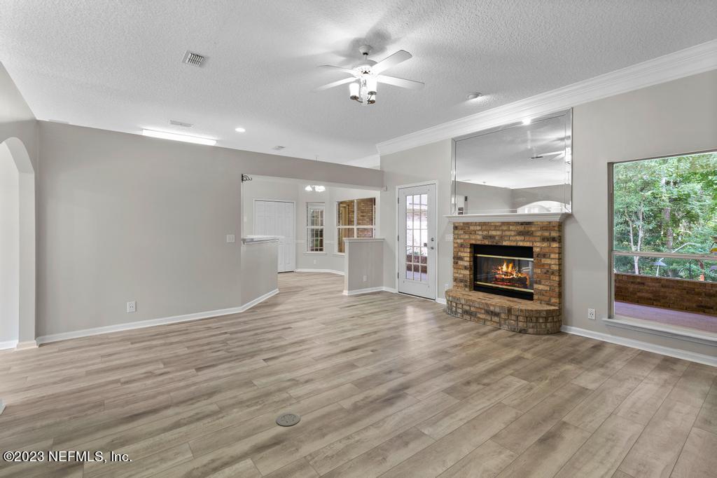 691 Nottingham Forest Circle St. Johns, FL 32259 - Photo 10 of 44 a view of empty room with wooden floor and fireplace