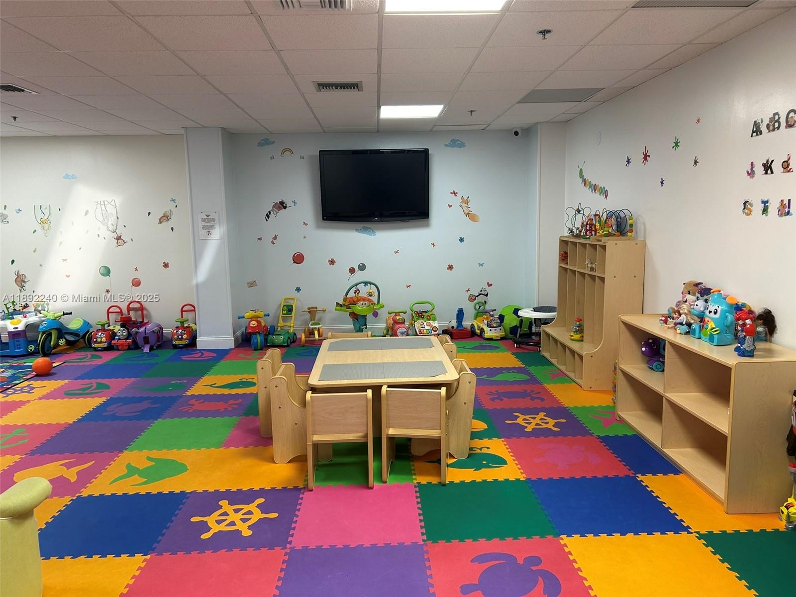 540 Brickell Key Drive, Unit 1602 Miami, FL 33131 - Photo 39 of 61 a room with lots of baby toys and flat screen tv