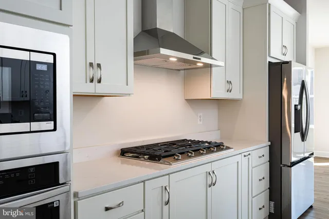 a kitchen with stainless steel appliances a stove a microwave and a refrigerator