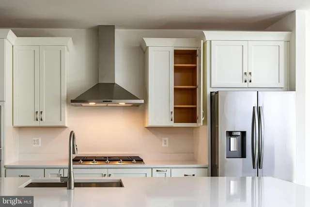 a kitchen with stainless steel appliances granite countertop a refrigerator and a stove